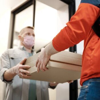 Man Wearing a Face Mask Receiving a Pizza Delivery